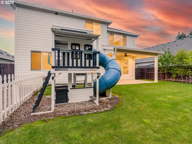 a view of house with a swimming pool and a yard