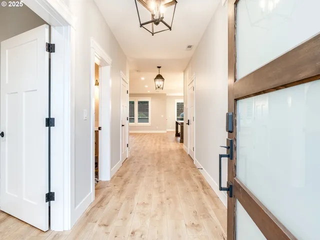 a view of a hallway with wooden floor and staircase