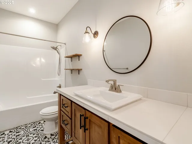 a bathroom with a sink a toilet and a mirror