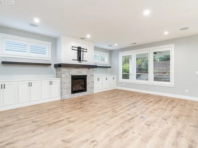 a view of an empty room with a fireplace and a window