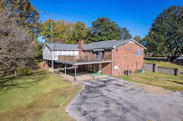a view of a house with backyard and trees