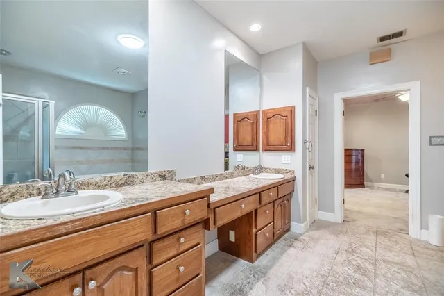 a spacious bathroom with a granite countertop double vanity sink mirror and