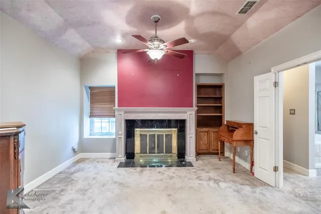 an empty room with ceiling fan and window