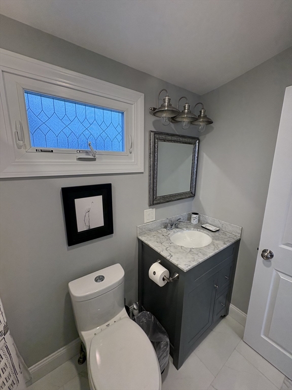 97 Washington Street, Unit 3 Gloucester, MA 01930 - Photo 5 of 15 a bathroom with a toilet sink and mirror