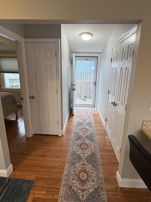 97 Washington Street, Unit 3 Gloucester, MA 01930 - Photo 9 of 15 a view of a hallway with wooden floor and stairs