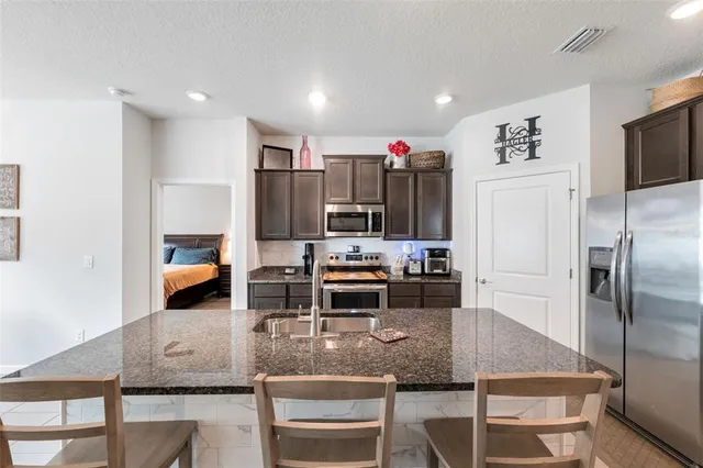 a kitchen with kitchen island a counter top space cabinets and stainless steel appliances