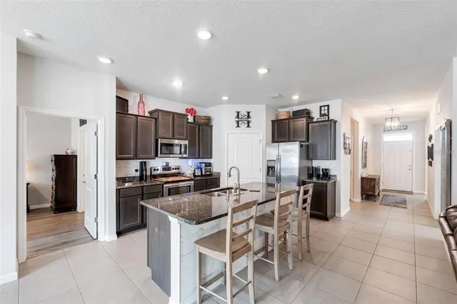 a kitchen with refrigerator and chairs