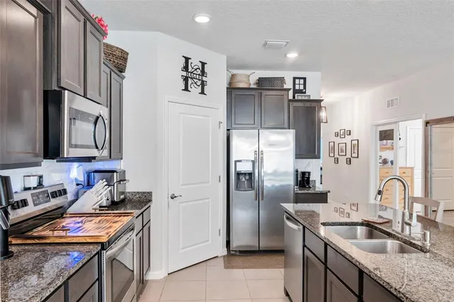 a kitchen with stainless steel appliances granite countertop a refrigerator and a sink