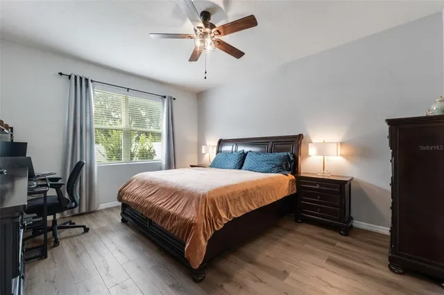 a bedroom with a bed a table and a large window