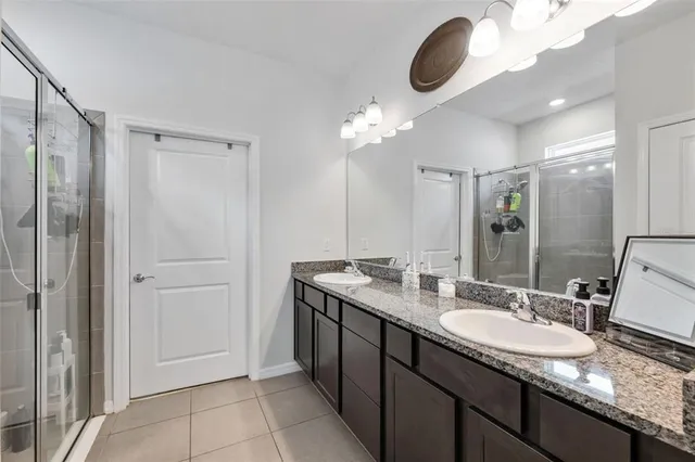 a bathroom with a granite countertop sink a light fixture and a mirror