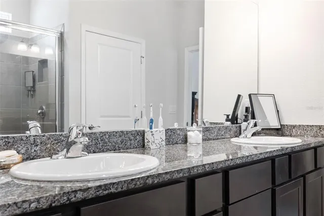 a bathroom with a granite countertop sink and a mirror