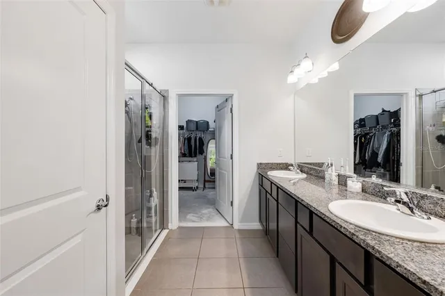 a bathroom with a granite countertop sink a mirror and a shower