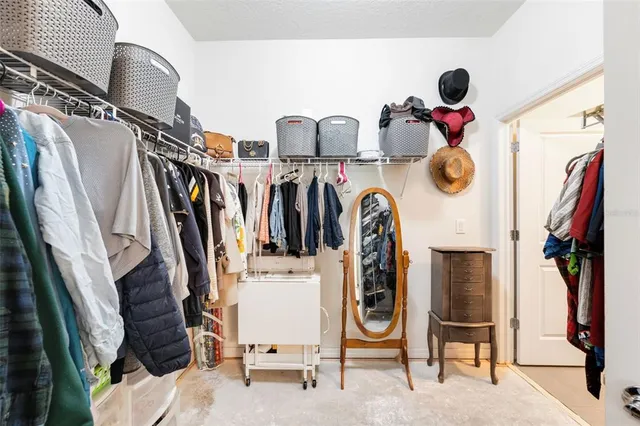 a view of walk in closet with clothes and shoes
