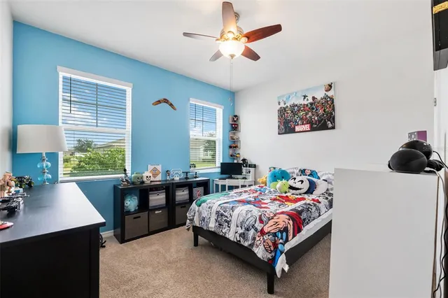 a bedroom with a bed and a table in it with window