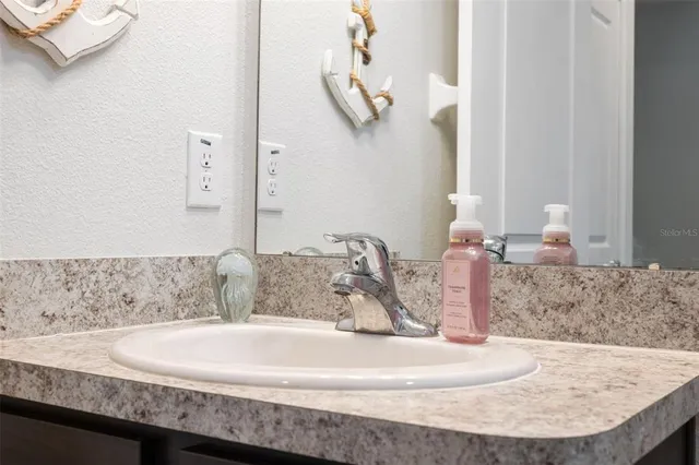 a bathroom with a granite countertop sink and a mirror