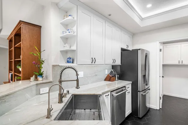 a kitchen with stainless steel appliances granite countertop a refrigerator and a stove top oven