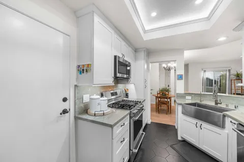a kitchen with stainless steel appliances a sink stove refrigerator and cabinets