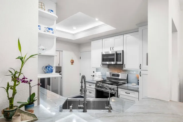 a kitchen with stainless steel appliances kitchen island granite countertop a refrigerator and a stove top oven