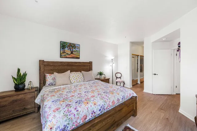 a bedroom with a bed and a potted plant
