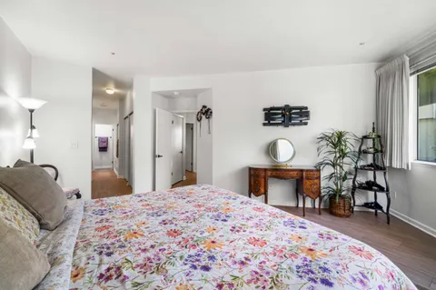 a bedroom with a bed and a table in it with wooden floor