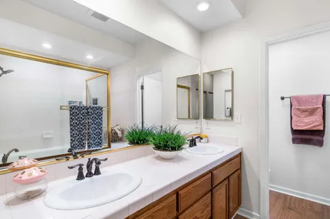 a bathroom with double vanity sinks and a mirror