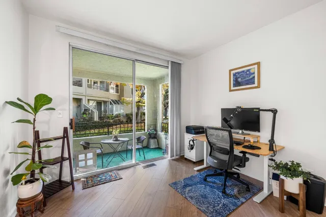 a view of a workspace with furniture and a window