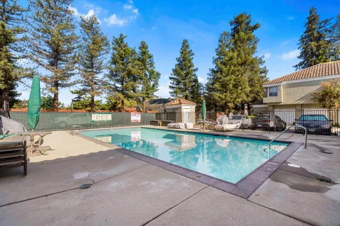 a view of swimming pool with outdoor seating and a garden