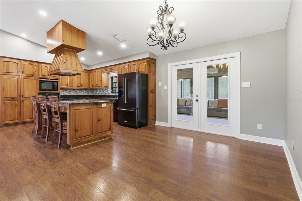 2331 D R Bryant Road Lakeland, FL 33810 - Photo 23 of 74 a view of a kitchen with stainless steel appliances granite countertop a refrigerator oven a sink dishwasher and white cabinets with wooden floor
