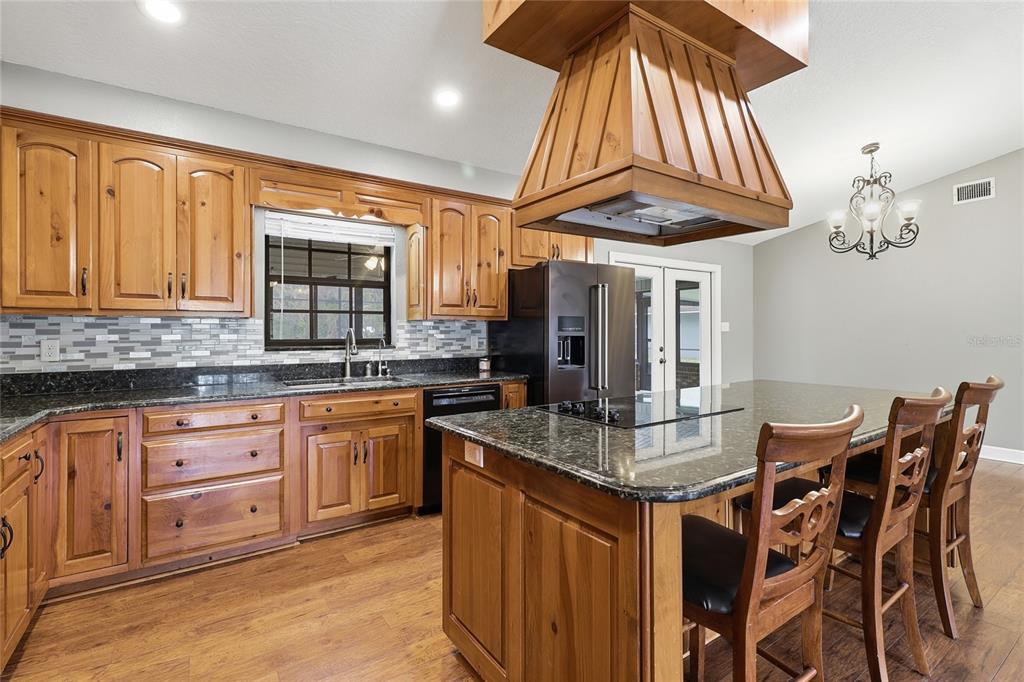 2331 D R Bryant Road Lakeland, FL 33810 - Photo 30 of 74 a kitchen with stainless steel appliances granite countertop a sink a stove and a wooden cabinets