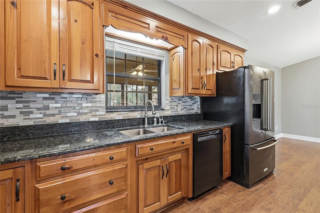2331 D R Bryant Road Lakeland, FL 33810 - Photo 31 of 74 a kitchen with granite countertop a sink and a refrigerator
