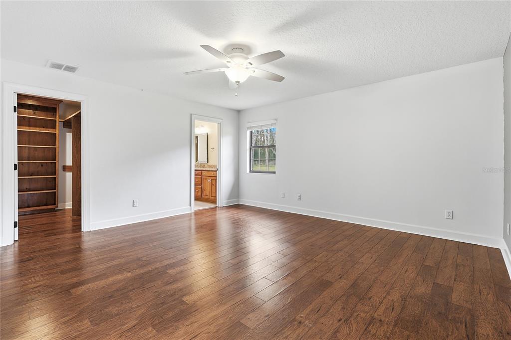2331 D R Bryant Road Lakeland, FL 33810 - Photo 33 of 74 an empty room with wooden floor chandelier fan and windows
