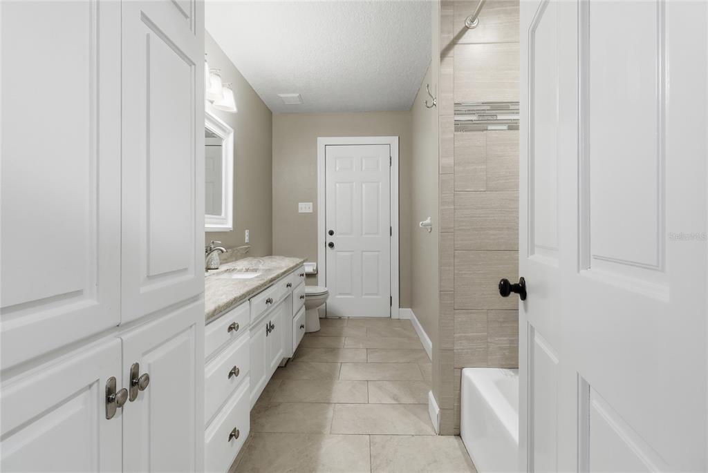 2331 D R Bryant Road Lakeland, FL 33810 - Photo 41 of 74 a bathroom with a granite countertop sink a mirror and a bathtub