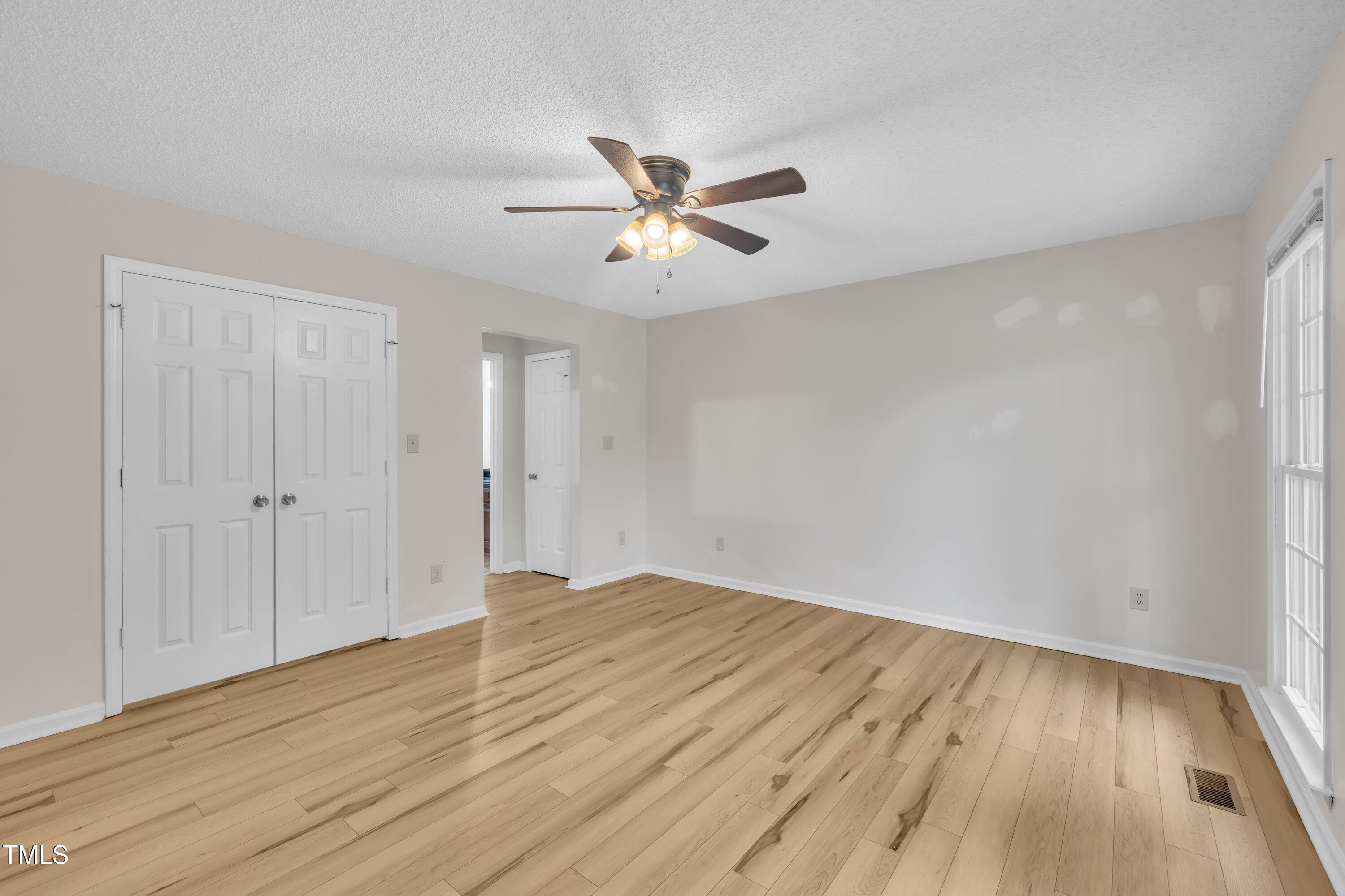 397 Meadow Road Kenly, NC 27542 - Photo 10 of 53 an empty room with wooden floor and windows