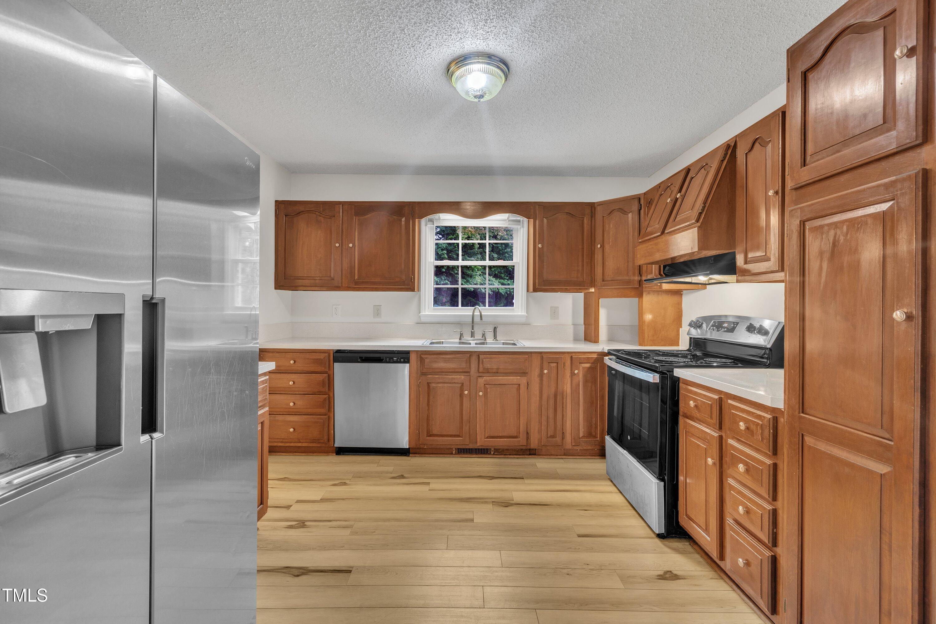 397 Meadow Road Kenly, NC 27542 - Photo 22 of 53 a kitchen with stainless steel appliances granite countertop a stove a sink dishwasher and a refrigerator with wooden floor