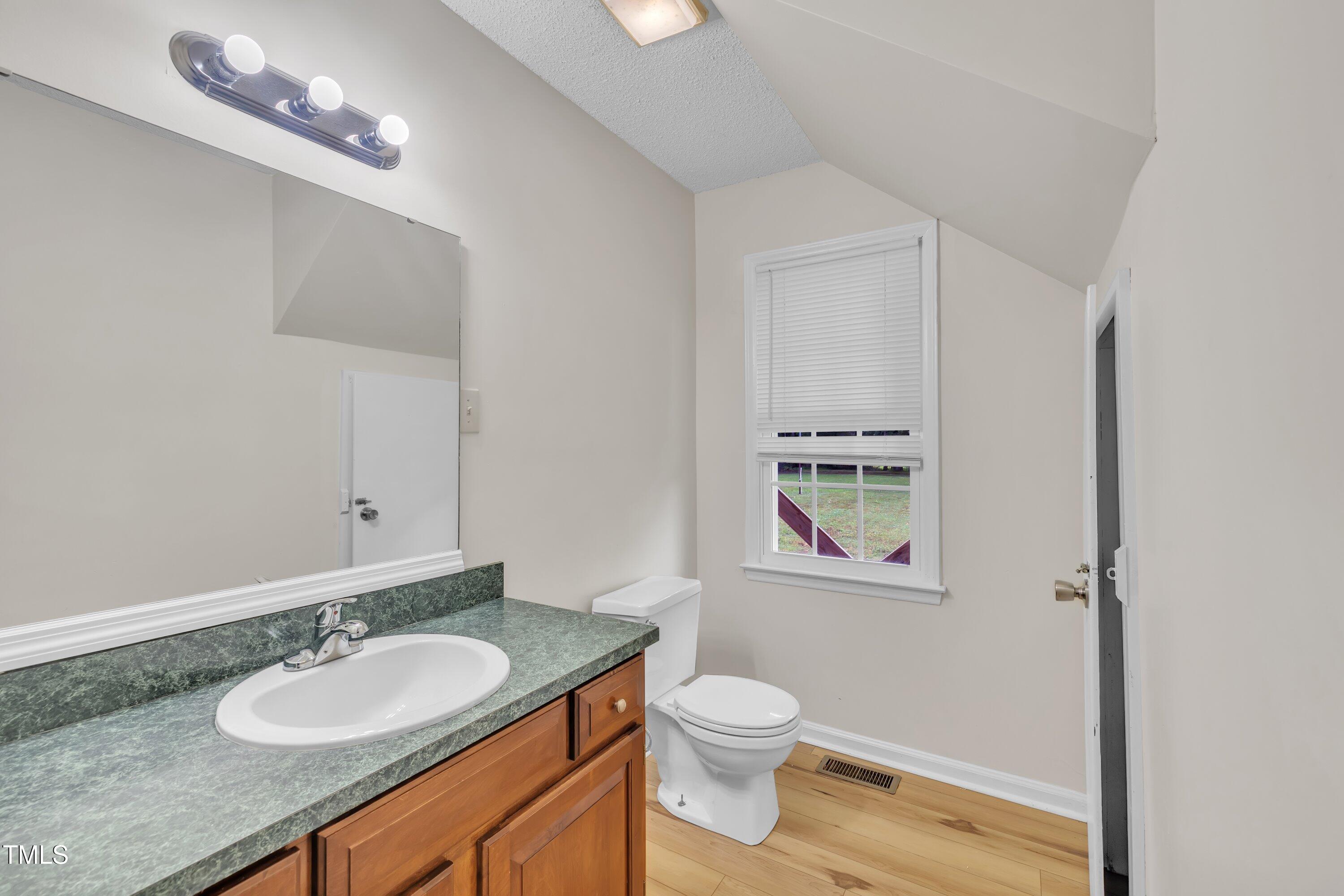 397 Meadow Road Kenly, NC 27542 - Photo 31 of 53 a bathroom with a granite countertop sink vanity mirror and toilet