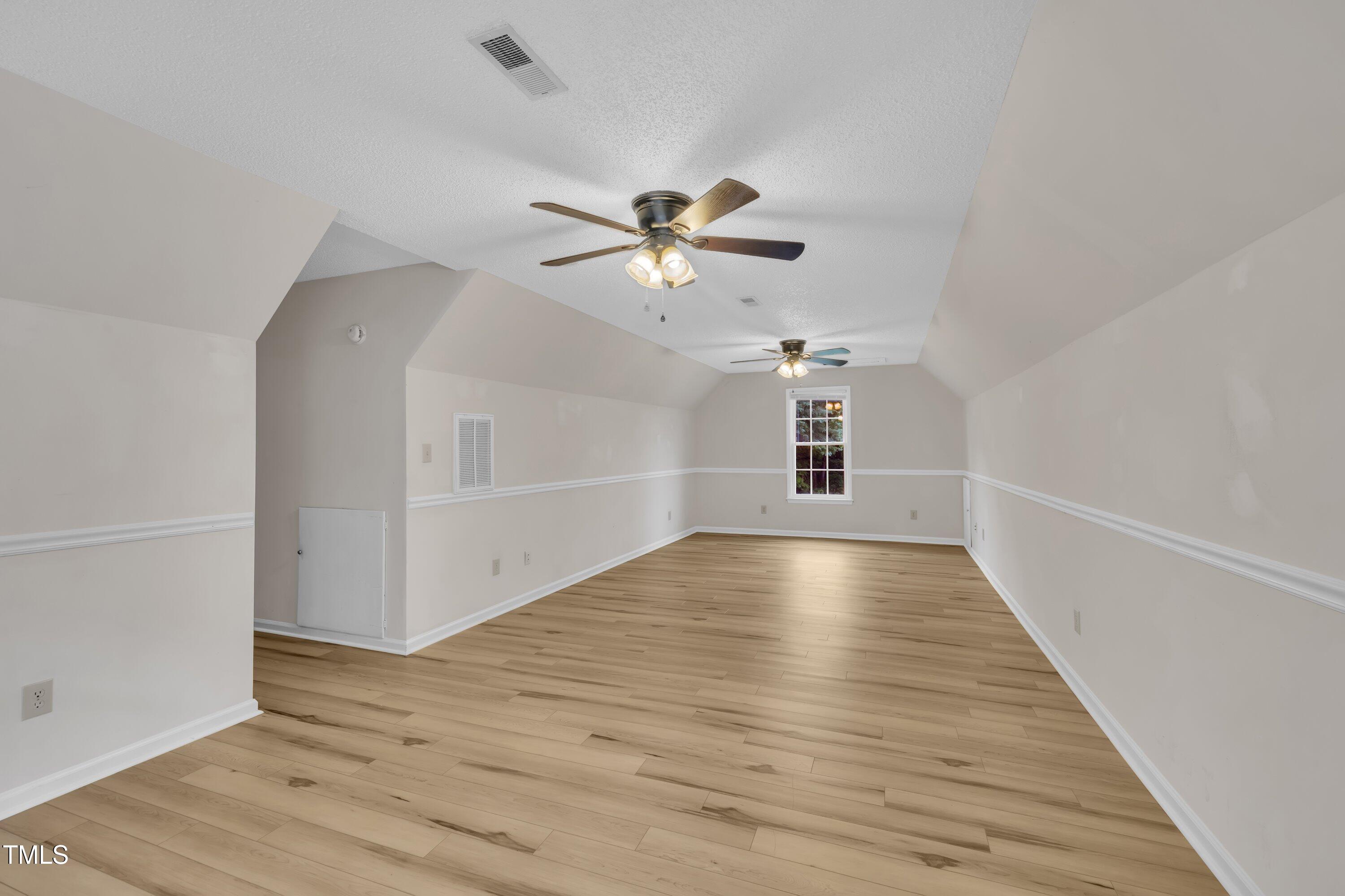 397 Meadow Road Kenly, NC 27542 - Photo 33 of 53 wooden floor in an empty room with a ceiling fan