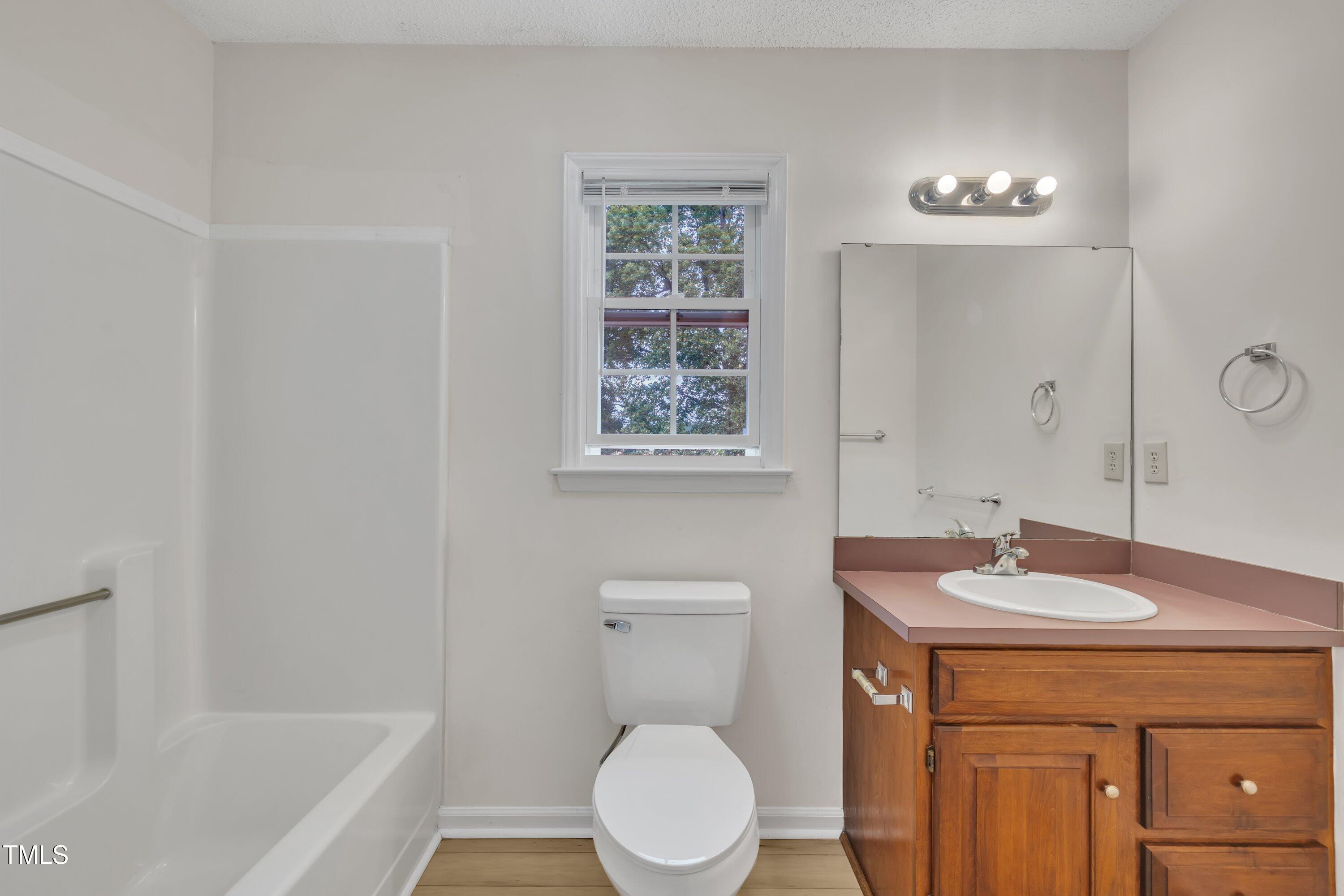 397 Meadow Road Kenly, NC 27542 - Photo 40 of 53 a bathroom with a granite countertop sink toilet and a bathtub