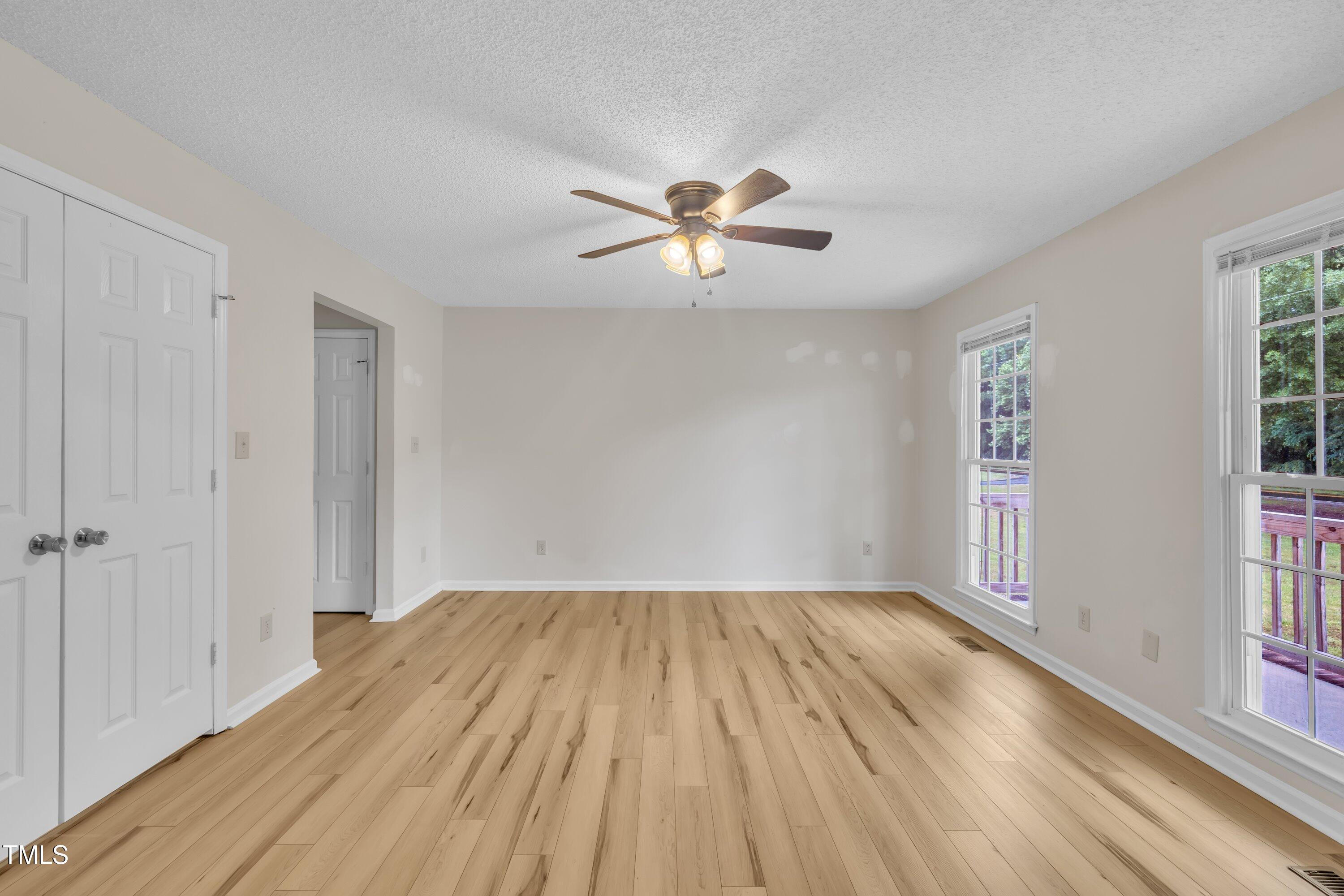 397 Meadow Road Kenly, NC 27542 - Photo 8 of 53 a view of empty room with wooden floor and fan