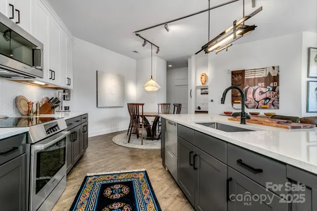a kitchen with stainless steel appliances granite countertop a sink stove and microwave