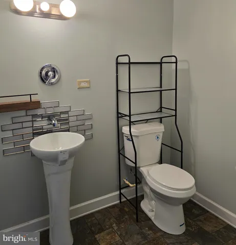 a bathroom with a toilet sink and mirror
