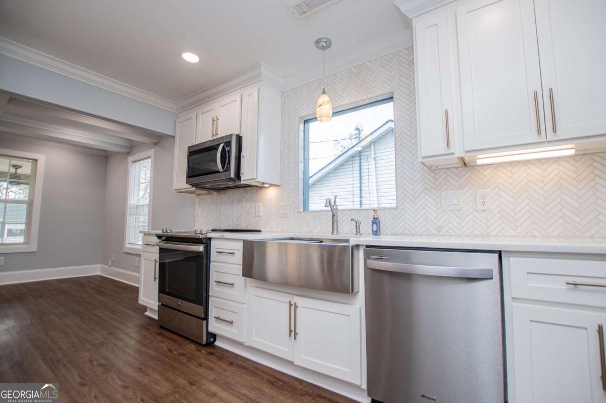 106 Mara Street Carrollton, GA 30117 - Photo 23 of 52 a kitchen with kitchen island granite countertop a sink cabinets and stainless steel appliances