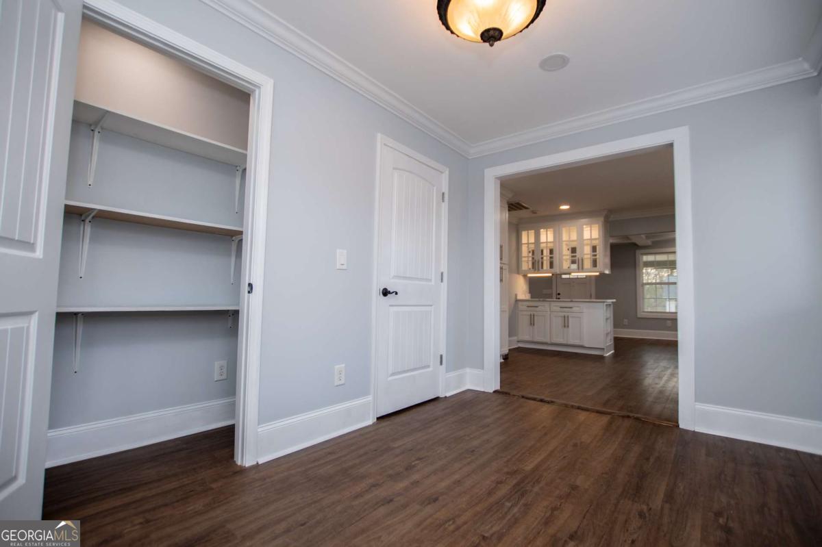 106 Mara Street Carrollton, GA 30117 - Photo 30 of 52 an empty room with wooden floor and mirror