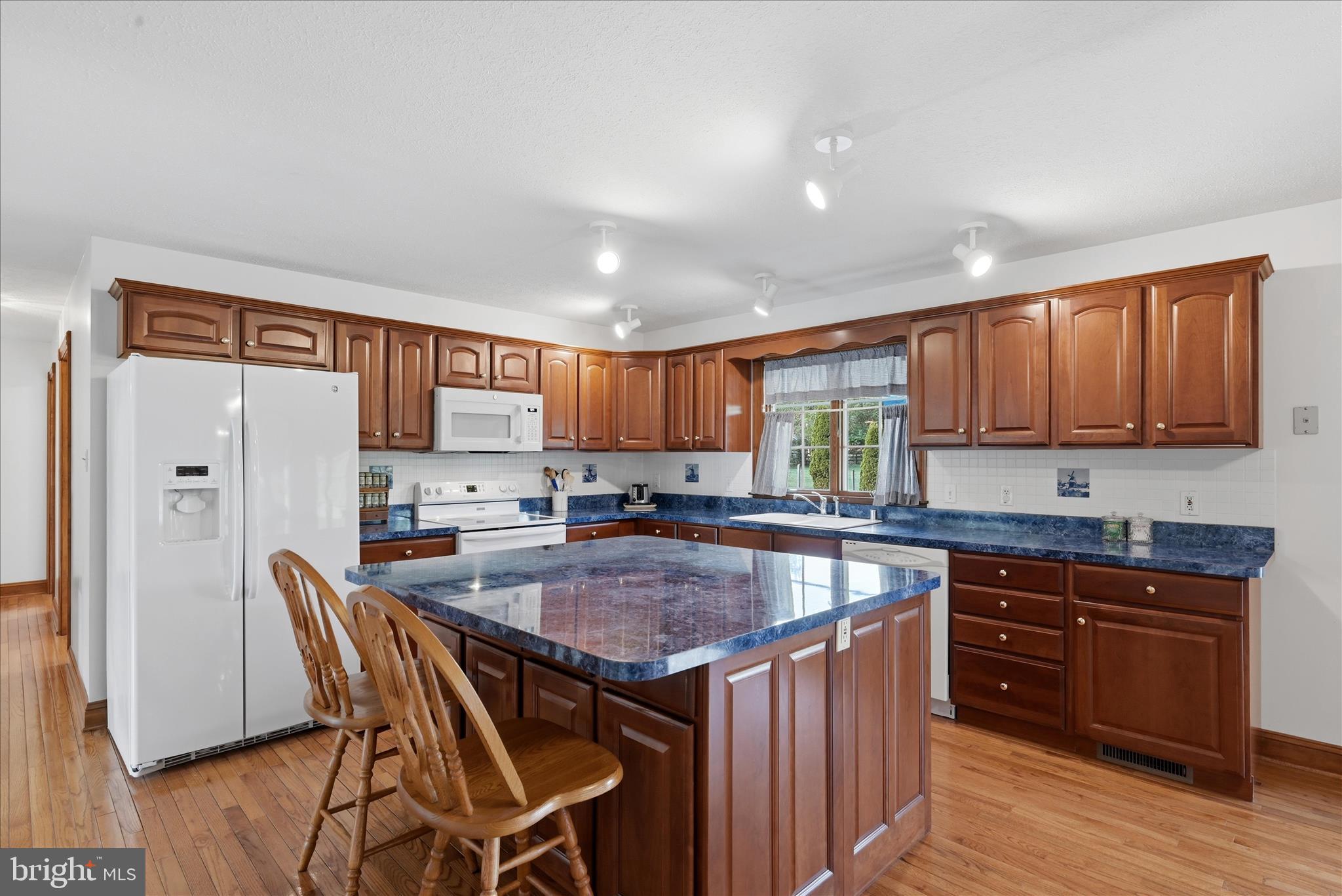 412 Ruebuck Road Clear Brook, VA 22624 - Photo 9 of 43 a kitchen with granite countertop kitchen island wooden cabinets and refrigerator