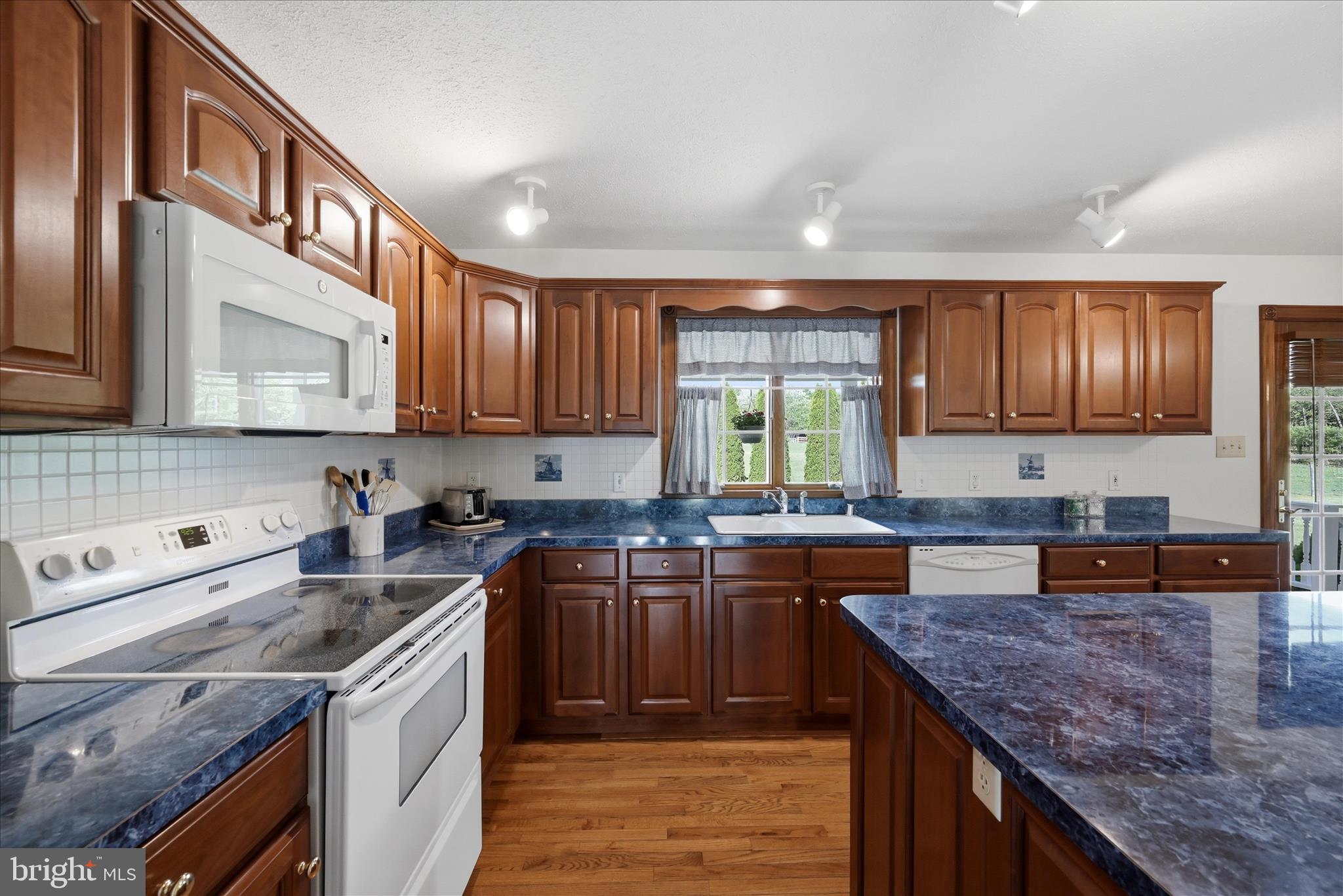 412 Ruebuck Road Clear Brook, VA 22624 - Photo 10 of 43 a kitchen with stainless steel appliances granite countertop wooden cabinets a stove top oven a sink and dishwasher