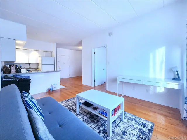a living room with furniture flat screen tv and kitchen view