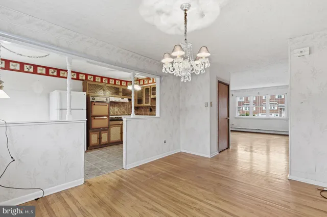 a view of a kitchen with refrigerator and wooden floor