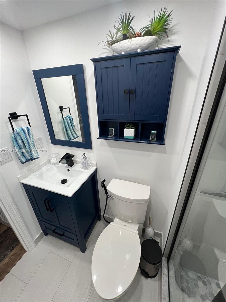 9880 Marina Boulevard, Unit 1516 Boca Raton, FL 33428 - Photo 19 of 32 a bathroom with a toilet sink and mirror