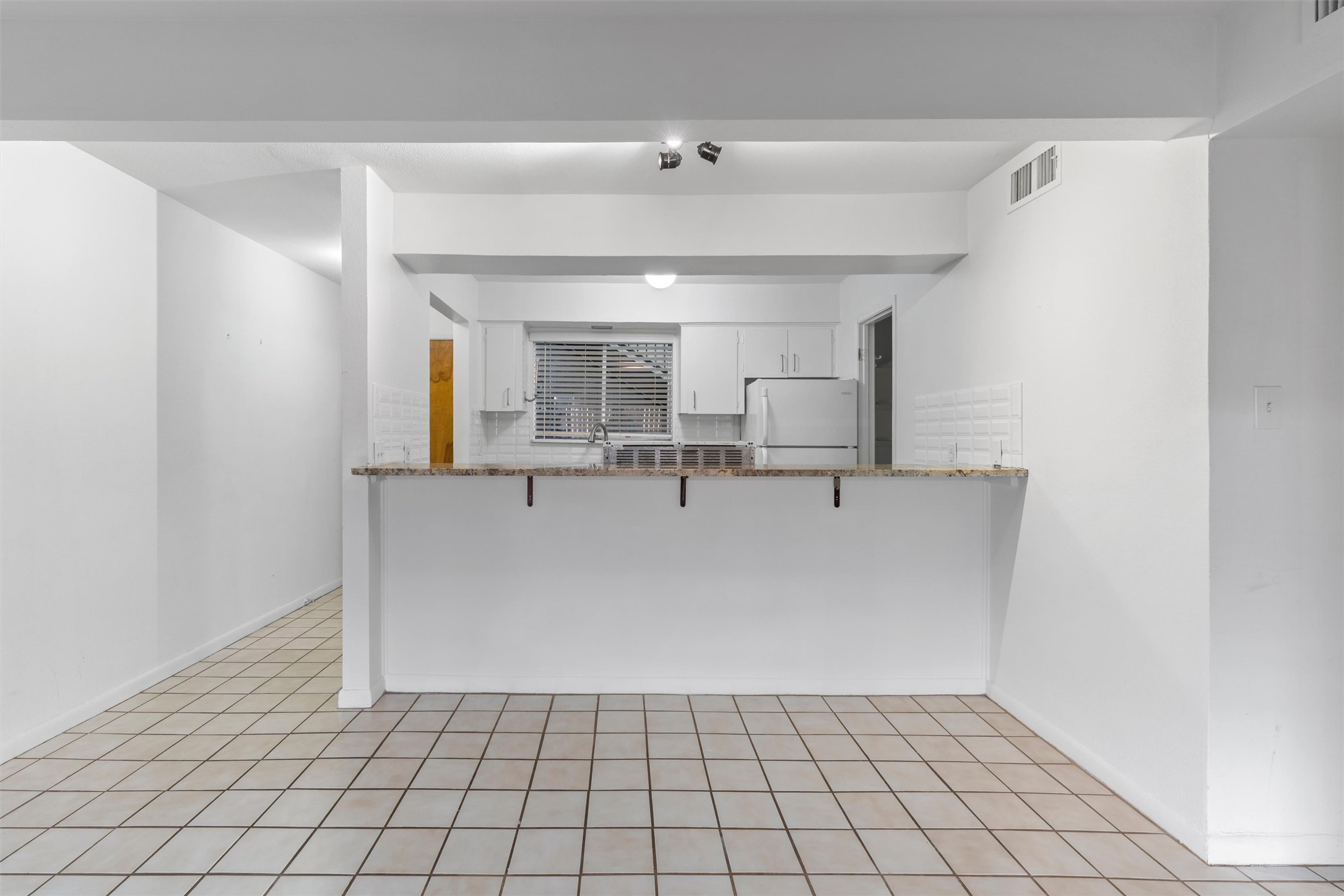 2208 Enfield Road, Unit 10500 Austin, TX 78703 - Photo 14 of 34 Open-concept kitchen featuring white cabinetry, a light-colored countertop, and a white subway tile backsplash