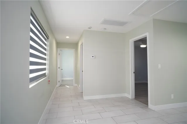 a view of a hallway with bathroom and a window