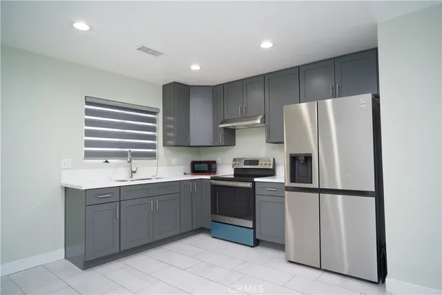 a kitchen with stainless steel appliances granite countertop a refrigerator sink and cabinets